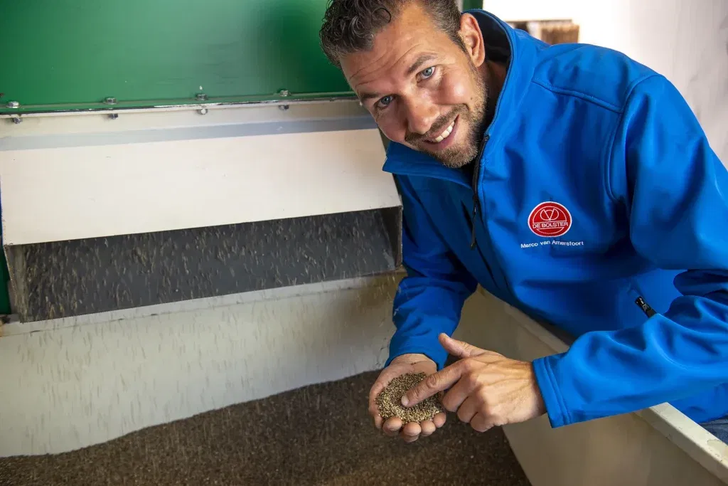 Medewerker van De Bolster demonstreert het zaadverwerkingsproces