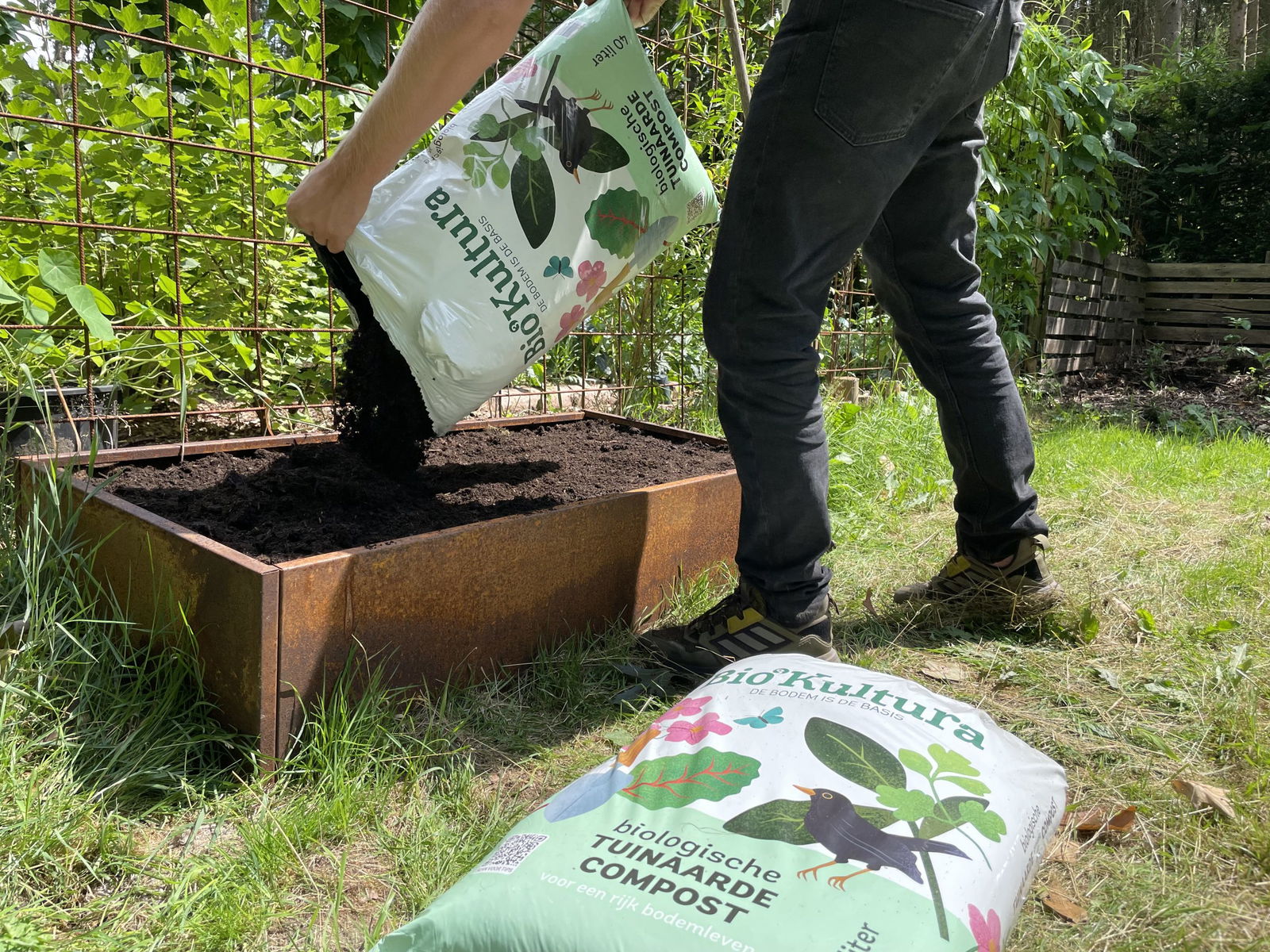 Plantenbak met goede regenwaterafvoer wordt gevuld met bio kultura tuinaarde compost