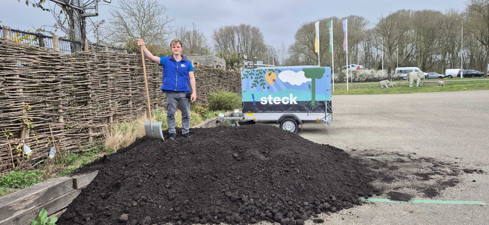 Een Steck-medewerker boven op een berg compost