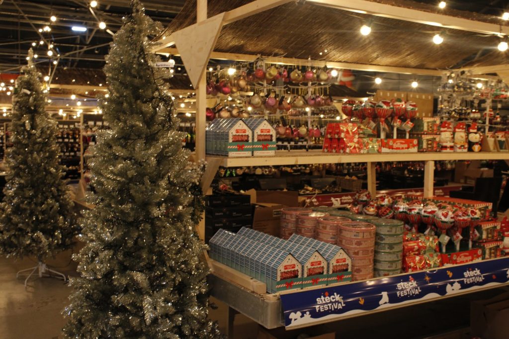 Besneeuwde kunstkerstboom bij een kraam op de kerstmarkt van Steck