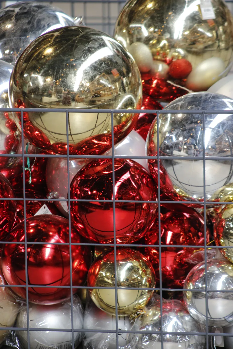 Een kooi vol rode, gouden en zilveren kerstballen