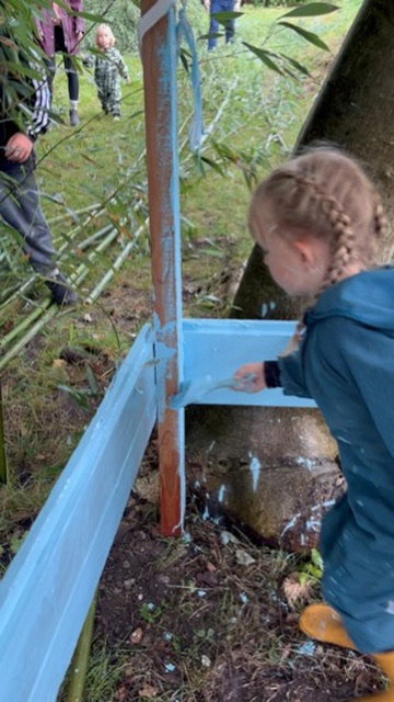 Meisje verft een hut lichtblauw in het bamboebos